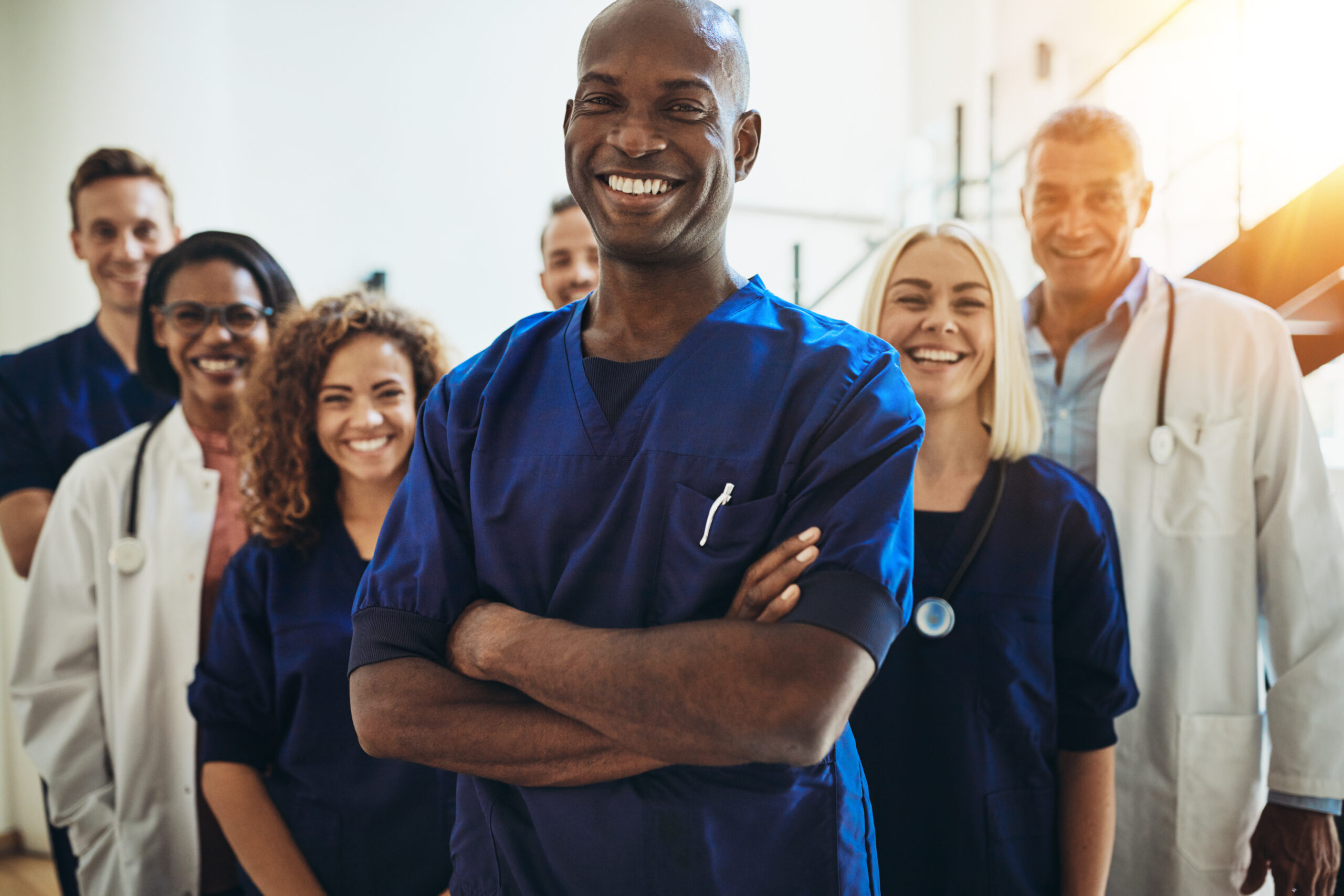 smiling-african-doctor-standing-in-a-hospital-with-his-staff